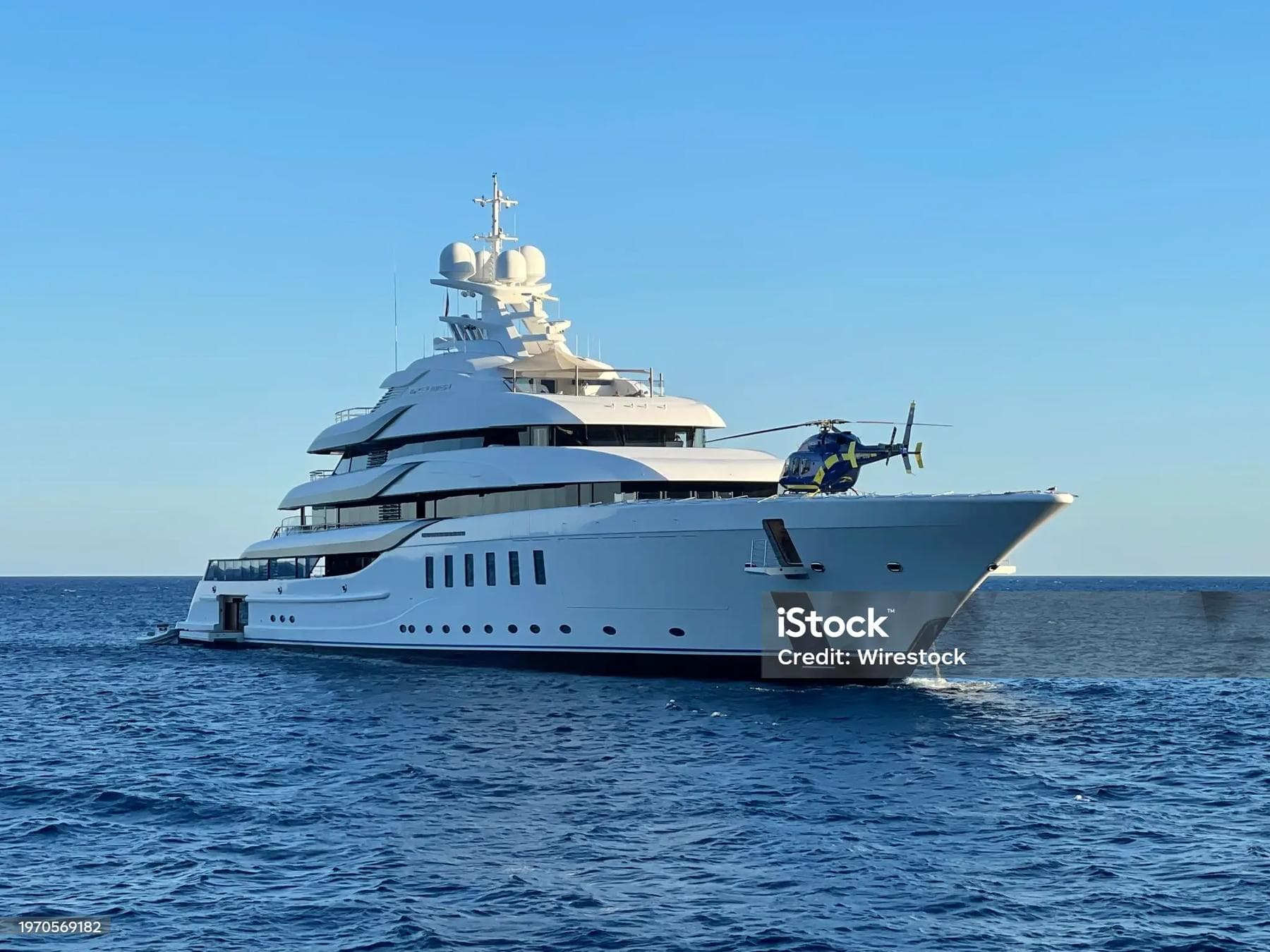 A superyacht with a helicopter on deep blue water