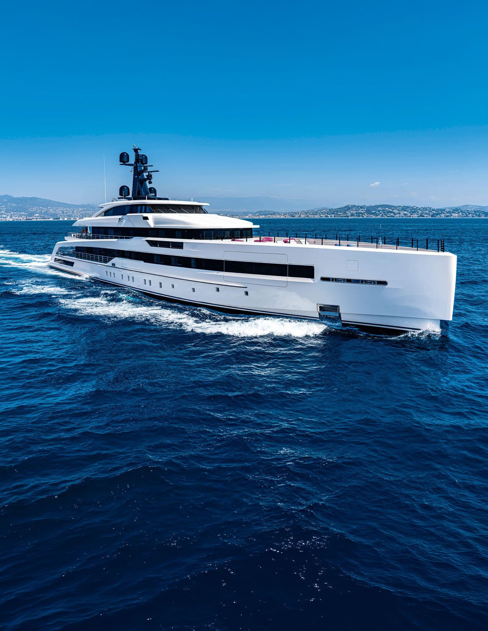 A white superyacht cruising on deep blue water